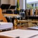 Violão, trompete, percussão e documentos ilustram licitações de instrumentos musicais