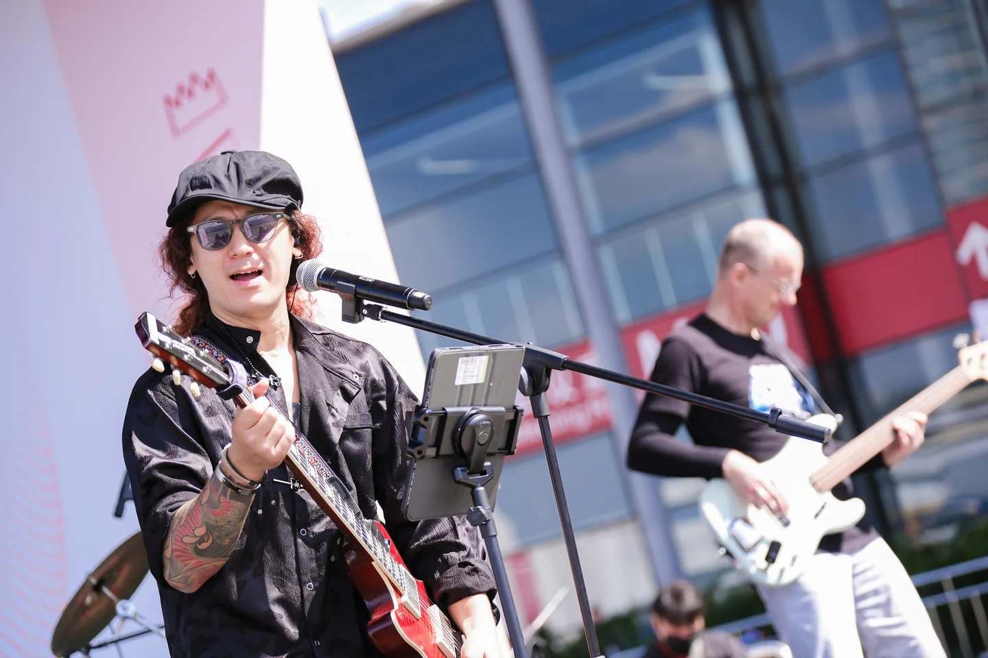 Apresentação musical na programação da Music China 2025 Músico canta ao microfone com uma guitarra durante apresentação na Music China.